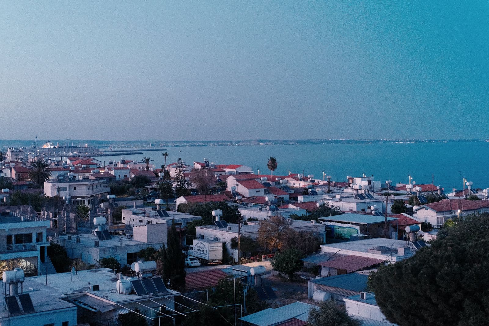 Aerial view of Larnaca's rooftops leading to the sea at sunset