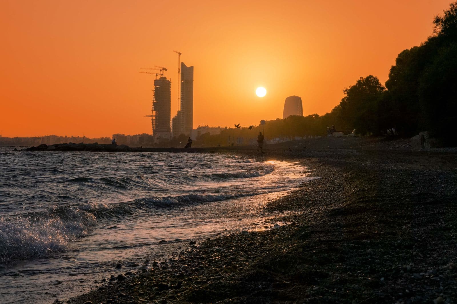 Sunset over the Limassol seafront with towers in the distance