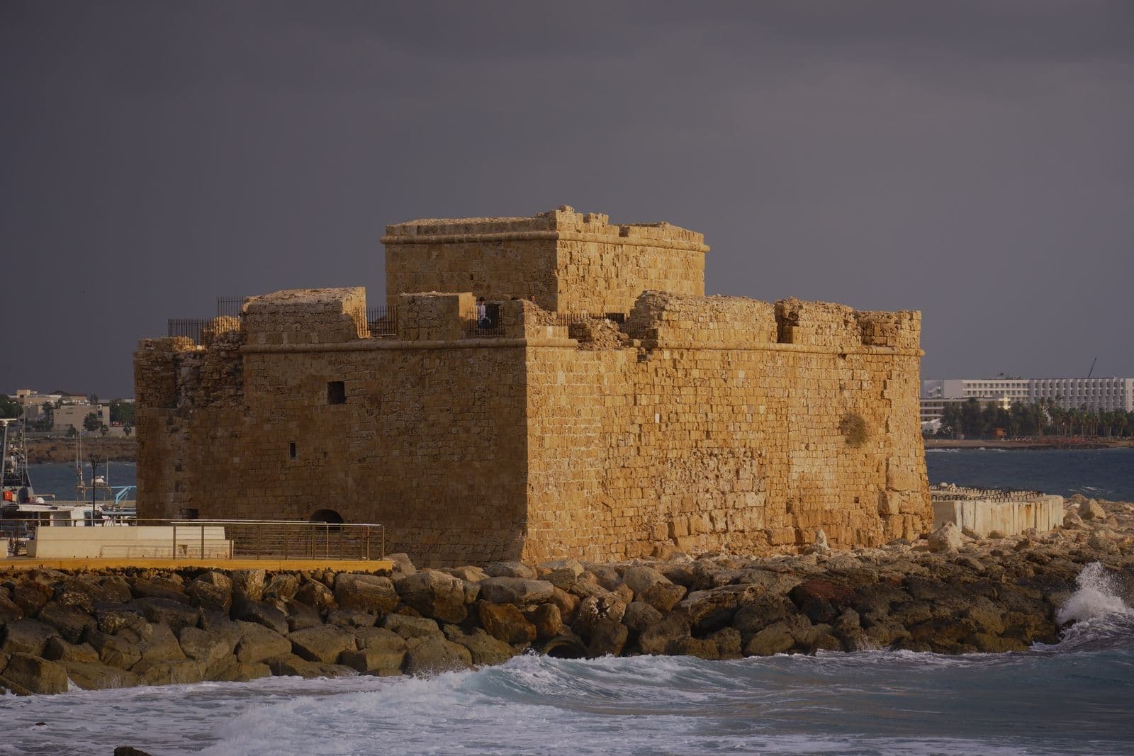 Paphos Castle, a medieval stone fort on the seafront, under a stormy sky